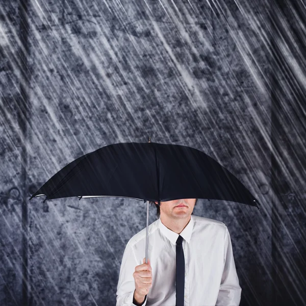 Geschäftsmann mit schwarzem Regenschirm schützt vor Regen — Stockfoto
