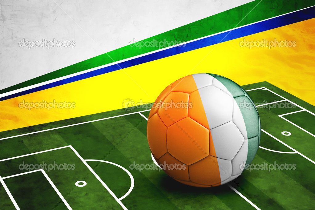 Soccer ball with Cote D'Ivore flag on pitch