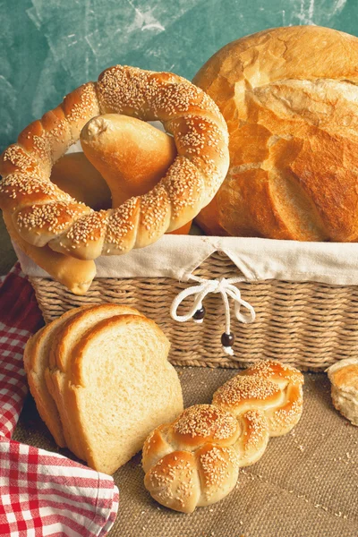 美味的面包和卷在柳条编织的篮子 — 图库照片