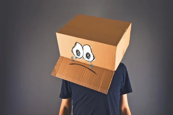 Man with cardboard box on his head and sad face expression — Stock Photo, Image