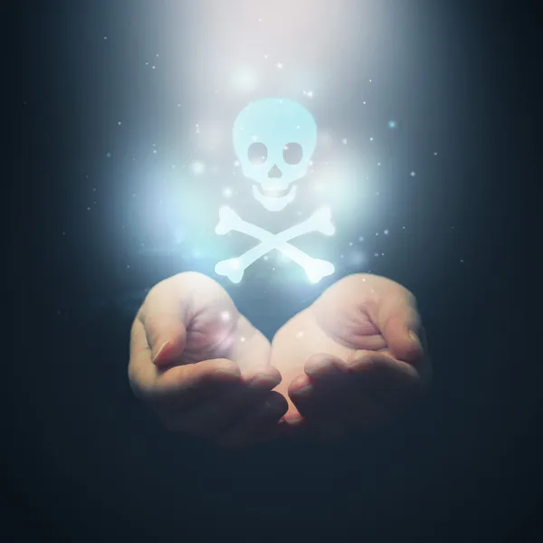 Female hands opening to light and skull — Stock Photo, Image