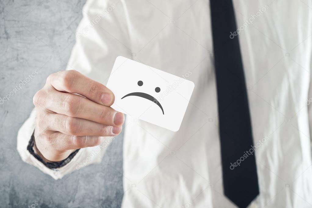 Businessman holding business card with sad face printed