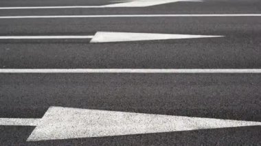 Düz yol geçiş araçları. Tek yönlü trafik. arabalar hareket halinde. beyaz çizgiler ve ok olarak yol işaretleri ve otomobil lastikleri odaklanmaktadır. meşgul sokak hayatı.