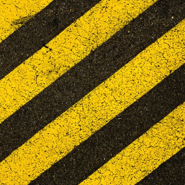 siyah asfalt üzerindeki sarı şeritli yol işaretleri.