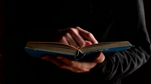 muž čtení otevřené bible v temné místnosti, náboženský pojem... 1920 x 1080, 1080p hd záběry.