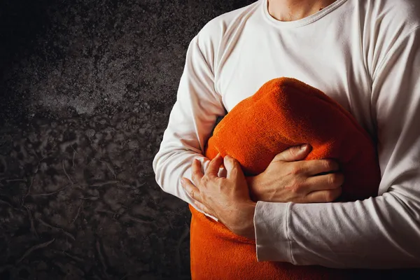 Uomo che abbraccia cuscino arancione — Foto Stock