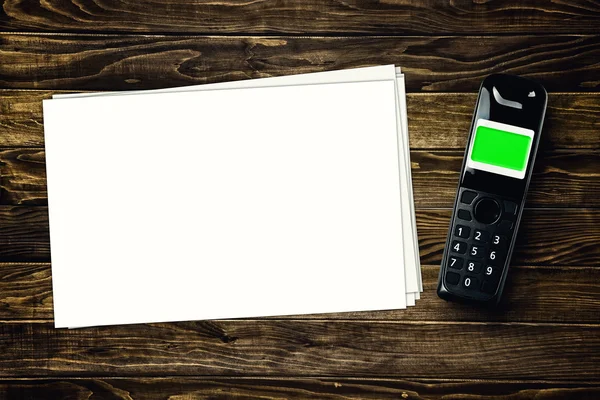 Wireless phone and blank paper on tabletop — Stock Photo, Image