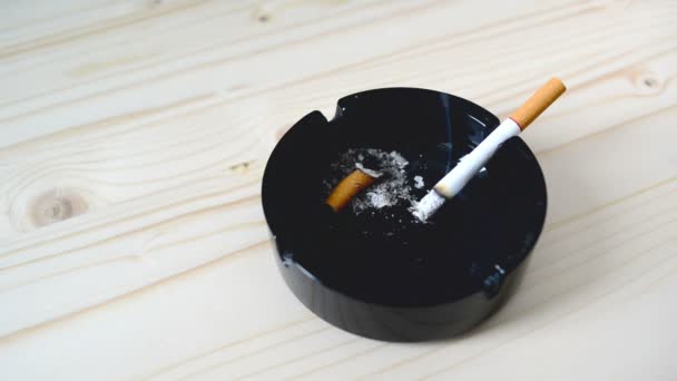 Cigarette burning in black ashtray on the table. 1920x1080, 1080p, full hd footage. — Stock Video