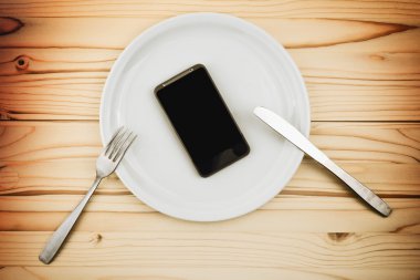 Beyaz tabakta yemek olarak servis mobil akıllı telefon