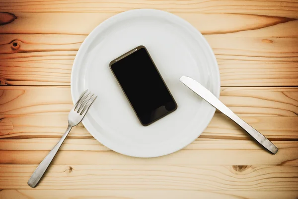 Teléfono inteligente móvil servido como cena en plato blanco —  Fotos de Stock