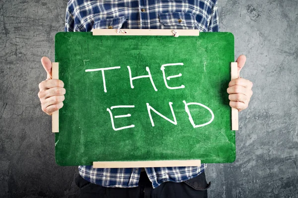 Uomo con lavagna verde con il titolo THE END — Foto Stock