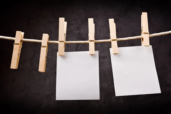 Duas notas de papel em branco penduradas na corda com pinos de roupas — Fotografia de Stock