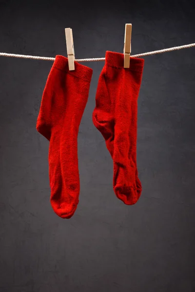 Old red socks hanging on rope — Stock Photo, Image