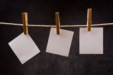 Giysi pimleri iple asılı üç boş kağıt notları