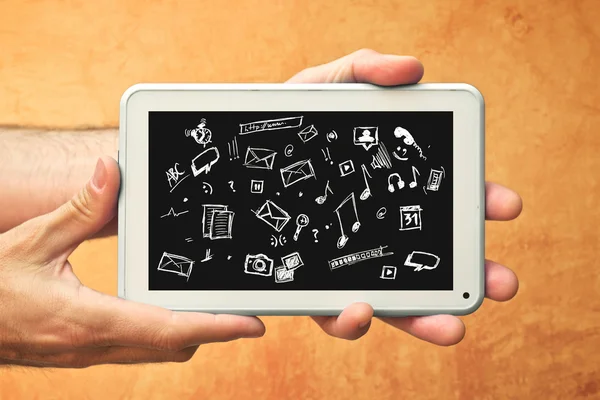 Handen met tablet pc en diverse doodle pictogrammen — Stockfoto