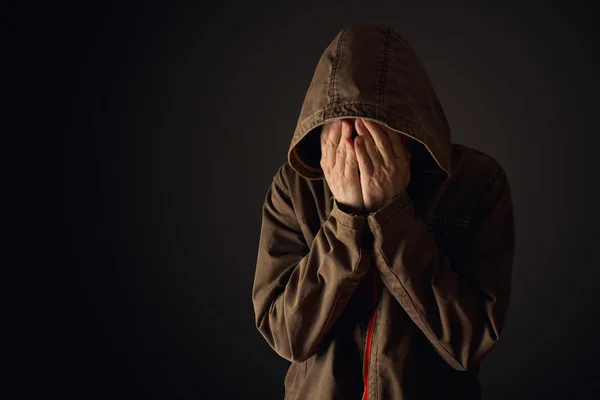 L'uomo depressivo in giacca con cappuccio sta piangendo — Foto Stock