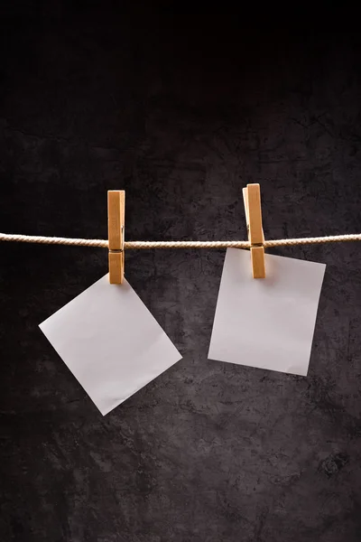 Dos notas de papel en blanco colgando de una cuerda con alfileres de ropa —  Fotos de Stock