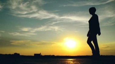 sunset caddesinde yürüyen kadın. güzel yaz gökyüzüne karşı dişi bir insan silüeti