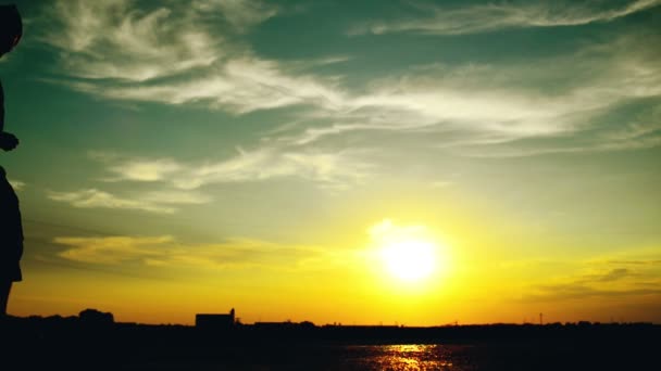 Un uomo che cammina per strada al tramonto. Silhouette di un uomo contro il bel cielo estivo. 1920x1080 riprese hd completo . — Video Stock