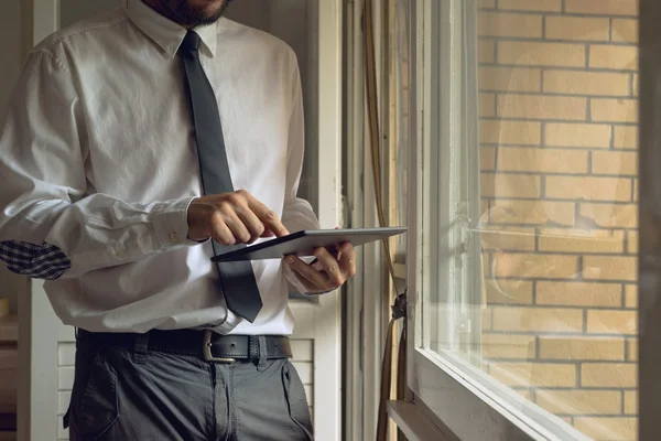 Businessman taps digital tablet computer — Stock Photo, Image