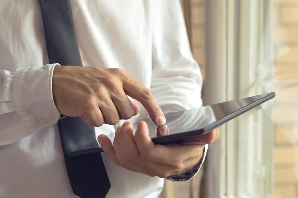 Businessman taps digital tablet computer — Stock Photo, Image