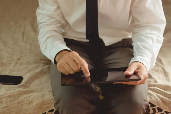 Lonely businessman in hotel room sitting on the bed — Stock Photo, Image