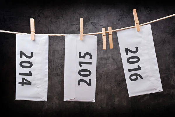 Three Envelopes with year numbers on clothes rope — Stock Photo, Image