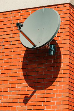 Ev tuğlası duvara monte edilmiş eski uydu anteni, seçici odaklı.