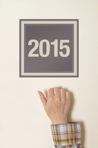 Woman knocking on door with number 2015 — Stock Photo, Image