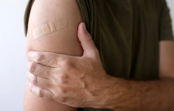 Covid 19ワクチン接種後の石膏を持つ男 選択的な焦点 — ストック写真