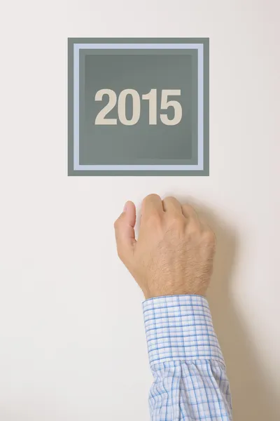 Businessman knocking on door with number 2015 — Stock Photo, Image