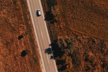 Yazın sonlarına doğru kırsal alanda uçan tek bir gri otomobilin görüntüsü.