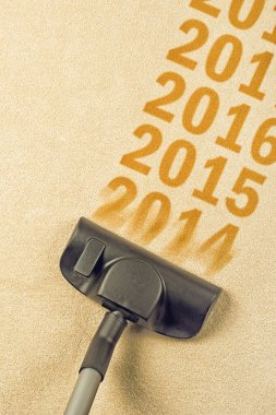 Vacuum Cleaner sweeping year number 2014 from carpet clipart