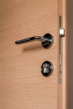 Orta yoğunluklu fiberboard yatak odası kapısının modern metal kapı kolu, seçici odaklı.