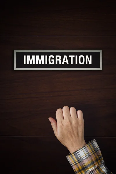 A mão está batendo na porta do escritório de imigração — Fotografia de Stock
