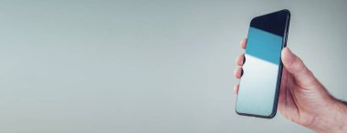 Erkek elinin cep telefonunun fotokopi alanı ile panoramik görüntüsü