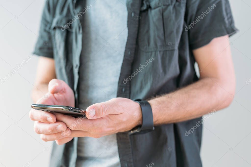 Casual man using smart mobile phone for communication, selective focus