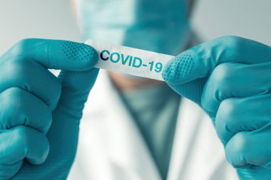 Aşı sonrası hastaya uygulanmak üzere Covid-19 etiketli tıbbi profesyonel beyaz alçı yaması, seçici odaklanma