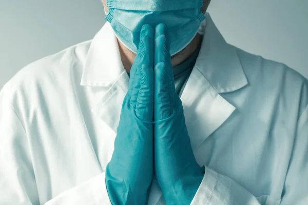 医療専門家は 祈りと嘆願の位置 選択的な焦点で手で保護手袋とフェイスマスクを身に着けている — ストック写真