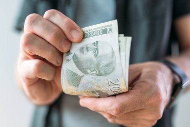 Sırp para birimi Dinar kağıt banknotları tutan adam, seçici odaklı