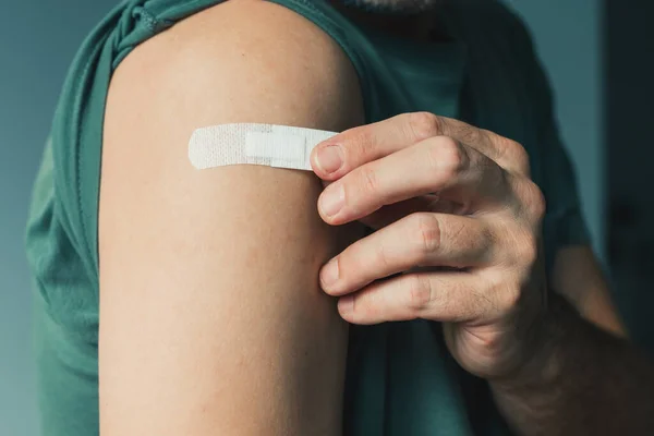 病院でのCovid 19ワクチン接種および予防接種手順の後の石膏による男性患者 選択的焦点 — ストック写真