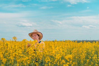 Kadın tarım uzmanı tarlada gelişen kolza tohumu tarlalarını araştırıyor, tarlada çalışan kadın, seçici odaklanma.