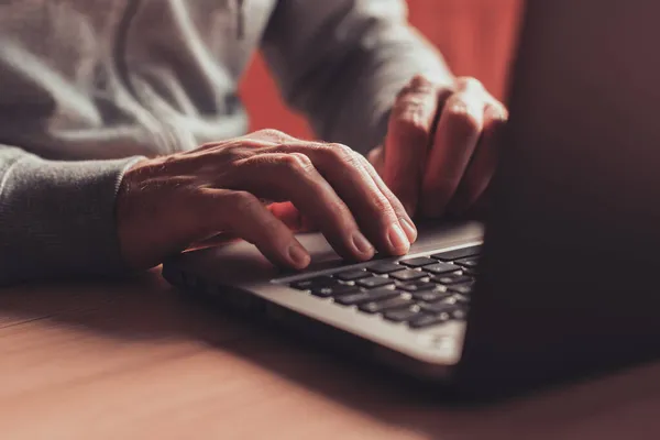 自宅のオフィスでノートパソコンのキーボードを入力する男 選択的な焦点で手の閉鎖 — ストック写真