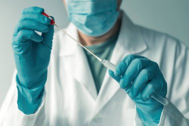 Covid-19 testi sırasında klinik laboratuarında numune örneği alan tıbbi uzman, seçici odaklanma