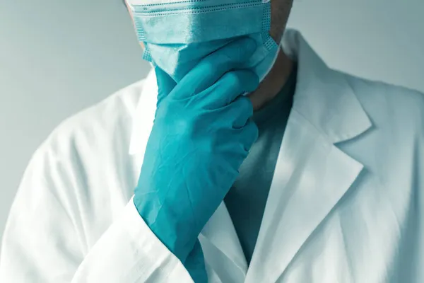 Profesional Médico Con Guantes Protectores Mascarilla Mano Barbilla Pensamiento Enfoque —  Fotos de Stock