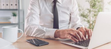 Ofisteki dizüstü bilgisayarda çalışan işadamı, seçici odaklı panoramik afiş