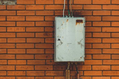 Tuğla duvardaki eski açık hava elektrik kabini.