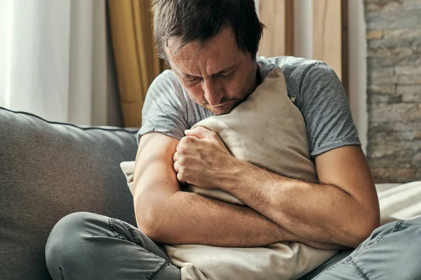 Homem Deprimido Sentado Sofá Sala Estar Travesseiro Abraçando Retrato Homem — Fotografia de Stock