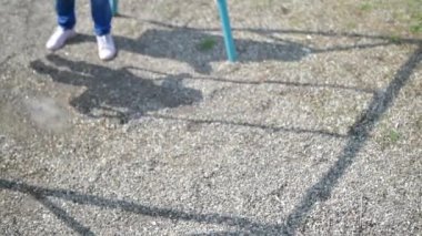 Anne ve çocuk oyun bahçesinde sabahın erken saatlerinde salıncak, seçici odaklanma