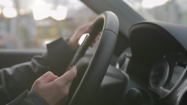 Kadın sürücü otoparktaki cep telefonundan mesaj atıyor, seçici odak noktasını kapat